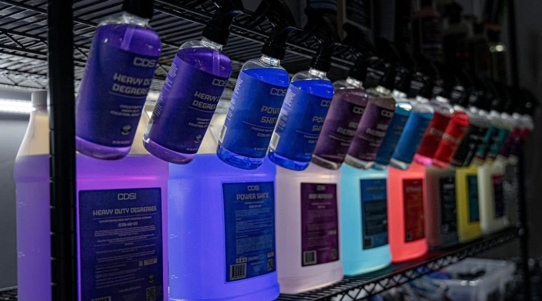 Row of CDS automotive fluids on a shelf with colorful labels.